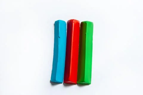 Three multi-colored plasticine bars on a white background. Stock Photos