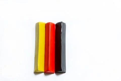 Three multi-colored plasticine bars on a white background. Stock Photos