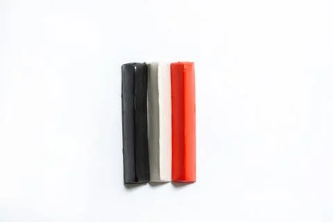 Three multi-colored plasticine bars on a white background. Stock Photos