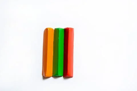 Three multi-colored plasticine bars on a white background. Stock Photos