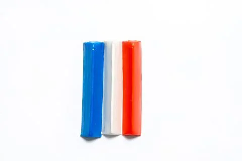 Three multi-colored plasticine bars on a white background. Stock Photos