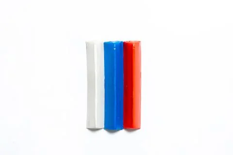 Three multi-colored plasticine bars on a white background. Stock Photos