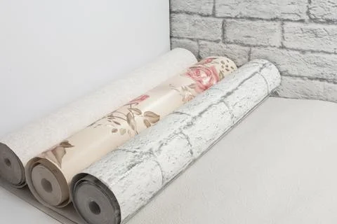 Three multi-colored rolls of wallpaper for apartment renovation. Apartment re Foto stock