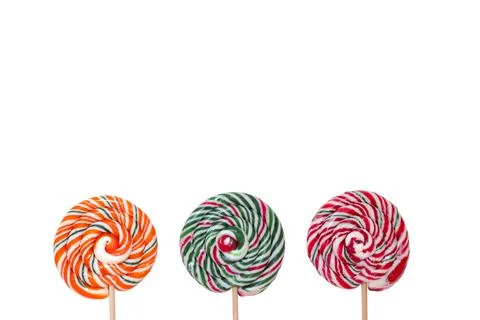 Three multi-colored round lollipops on wooden sticks on a white background Stock Photos