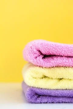 Three multi-colored Terry towels have a yellow wall on white background Stock Photos