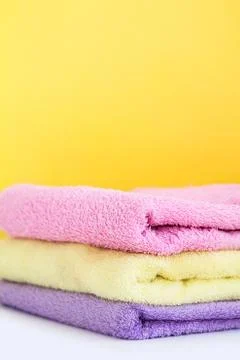 Three multi-colored Terry towels have a yellow wall on white background Stock Photos