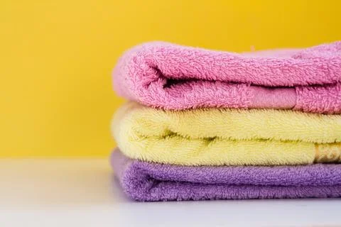 Three multi-colored Terry towels have a yellow wall on white background Stock Photos