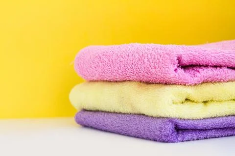 Three multi-colored Terry towels have a yellow wall on white background Foto stock
