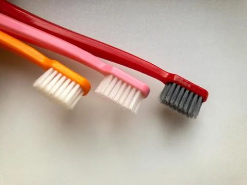 Three multi-colored toothbrushes on a white background Stock Photos