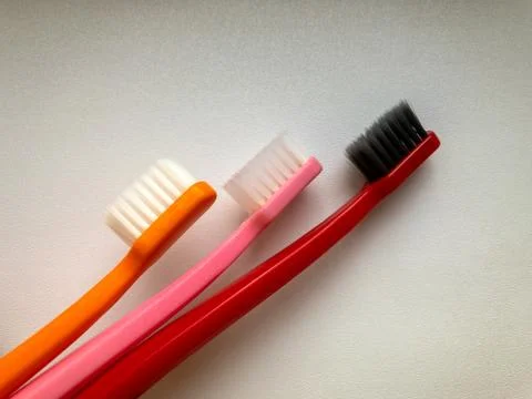Three multi-colored toothbrushes on a white background 写真素材
