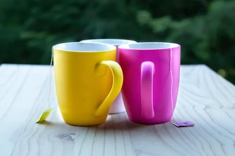 Three multi coloured mugs with tea Stock Photos