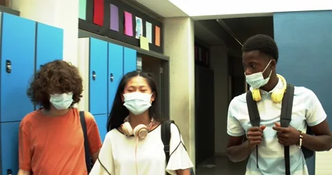 Three multi-ethnic teens with face masksn the hallways of the institute Stock Footage 157807655