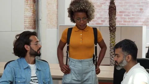 Three multi-ethnic workers talking in an office or coworking. Startup Stock Footage 158008233