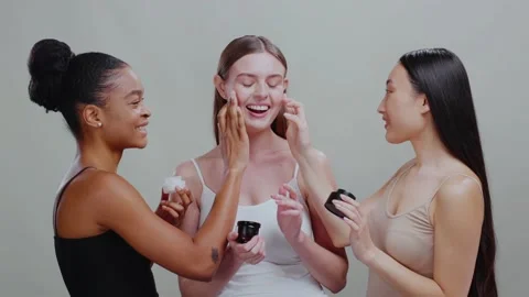 Three multi-race beautiful young active women isolated on background trying on Stock Footage 143933708
