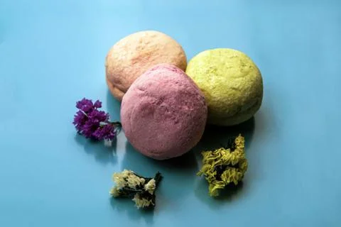 Three multicolor macaroons on the blue paper background. top view. Stock Photos