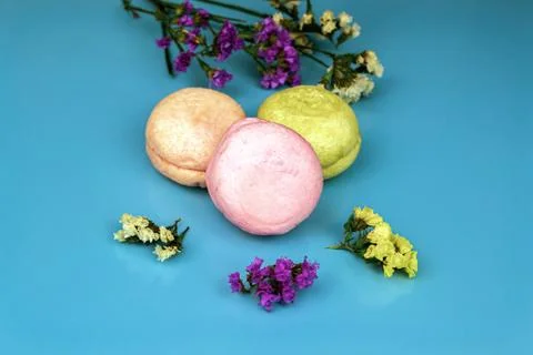 Three multicolor macaroons on the blue paper background. top view. Stock Photos