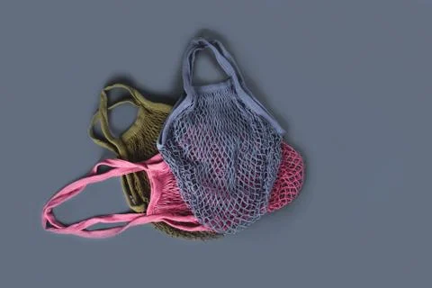 Three multicolor reusable string bags for different products. Stock Photos