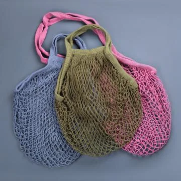 Three multicolor reusable string bags for different products. Stock Photos