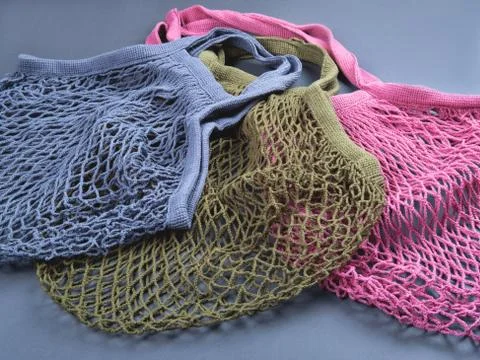 Three multicolor reusable string bags for different products. Stock Photos