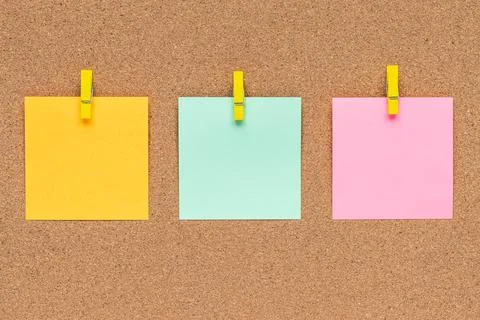 Three multicolor sticky notes on cork bulletin board Stock Photos