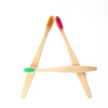 Three multicolored bamboo toothbrushes isolated on a white background. squa.. Stock Photos