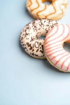 Three multicolored donuts on a blue background 库存照片