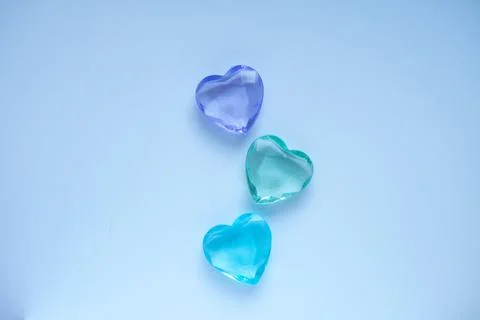 Three multicolored hearts on a blue background. Stock-Fotos