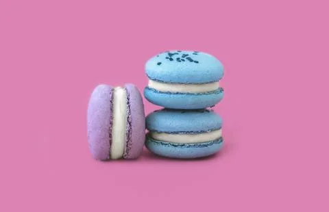 Three multicolored macarons on a pink background Stock Photos