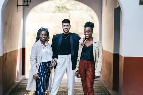 Three multiethnic friends standing while looking the camera outdoors Stock Photos