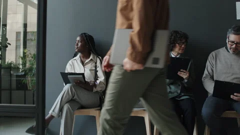 Three Multiethnic People Waiting For Interview While Caucasian Man Passing By Stock Footage 236701649
