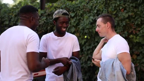 Three multiracial friends chatting and laughing in the street Stock Footage 140976383