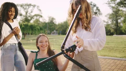 Three multiracial friends one disabled in a wheelchair enjoy a sunny day Stock Footage 313399654