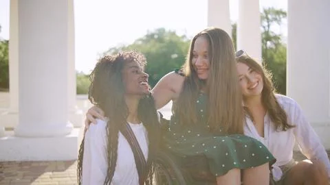 Three multiracial friends one disabled in a wheelchair enjoying a sunny day.. Stock Photos