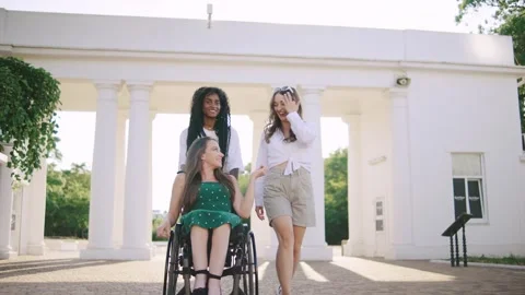 Three multiracial friends share a joyful moment as they explore a park, with one Stock Footage 313399520
