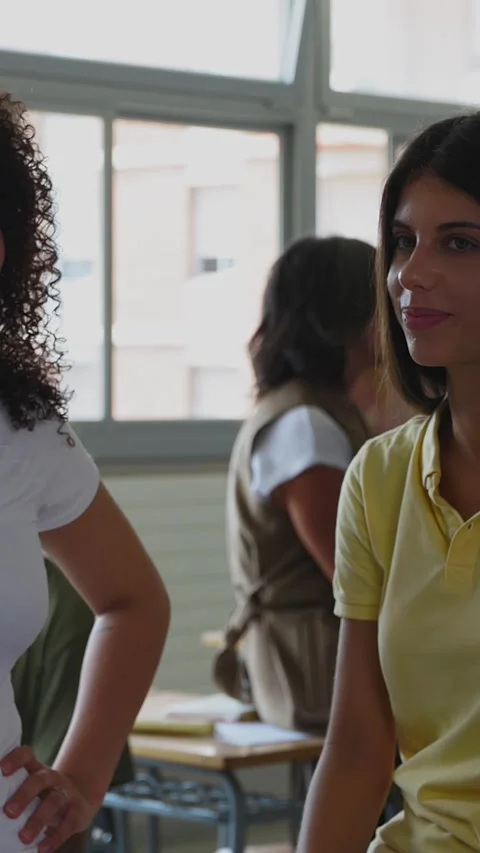 Three multiracial high school students hanging out in classroom during break Stock Footage 312200294
