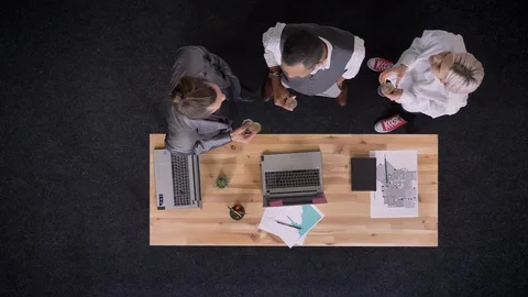 Three multy-ethnic workers are standing with glasses of champagne near table Video stock 92184009