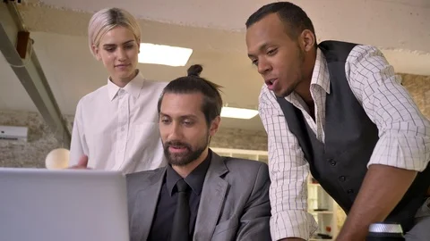 Three multy-ethnic workers discuss idea on laptop, coworking concept Video stock 92177161