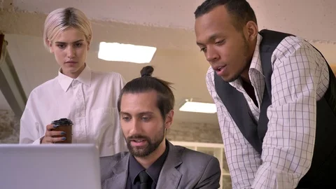 Three multy-ethnic workers discuss idea on laptop in office, coworking concept Video stock 92177299