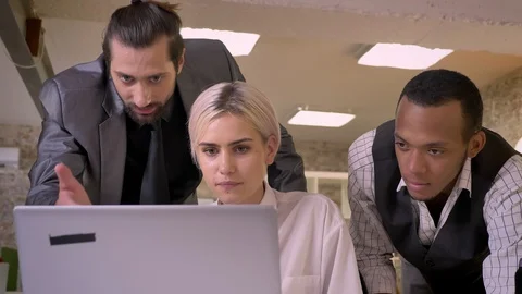 Three multy-ethnic workers discuss idea on laptop, coworking concept Video stock 92177421