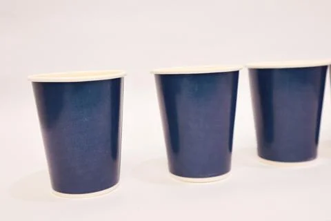 Three navy blue disposable cups lined up on a clean white background, for d.. Stock Photos