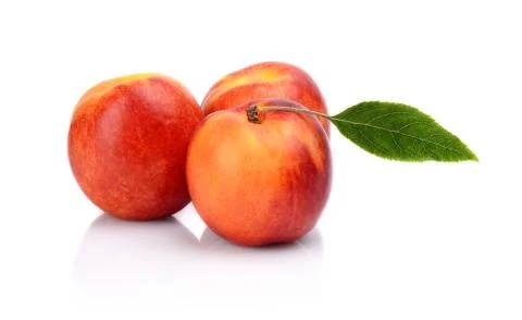 Three nectarines with leaf isolated on white background Stock Photos