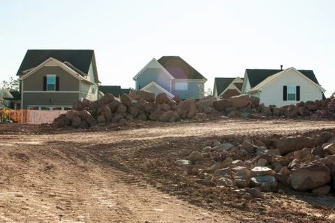 Three newly constructed homes surrounded by rubble Stock Photos