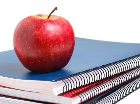 Three notebooks and a red apple Stock Photos