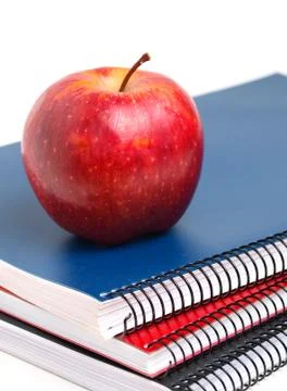 Three notebooks and red apple in vertical composition Stock Photos