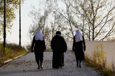 Three nuns view from the back, go together to the temple. spirituality, Catho Stock Photos
