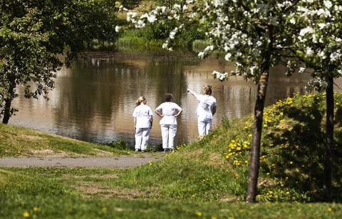 Three nurses have a break during the pandemic by a small lake Stock Photos