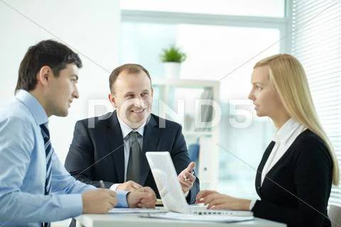 Three office workers discussing business issues in board room Stock Photos