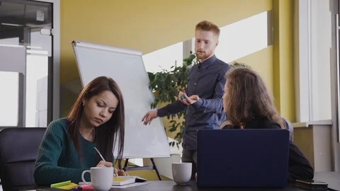 Three office workers, man and two woman, sitting at desk with computers. Stock Footage 119440327