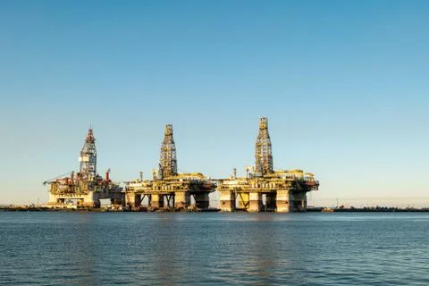 Three offshore oil rig platforms are in dry dock for maintenance. Stock Photos