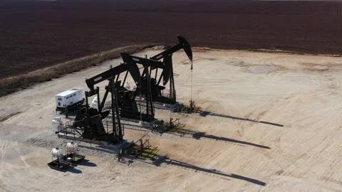 Three Oil Well Pump Jacks and a Plowed Field, Brazos County, Texas, USA Stock Footage 145948948